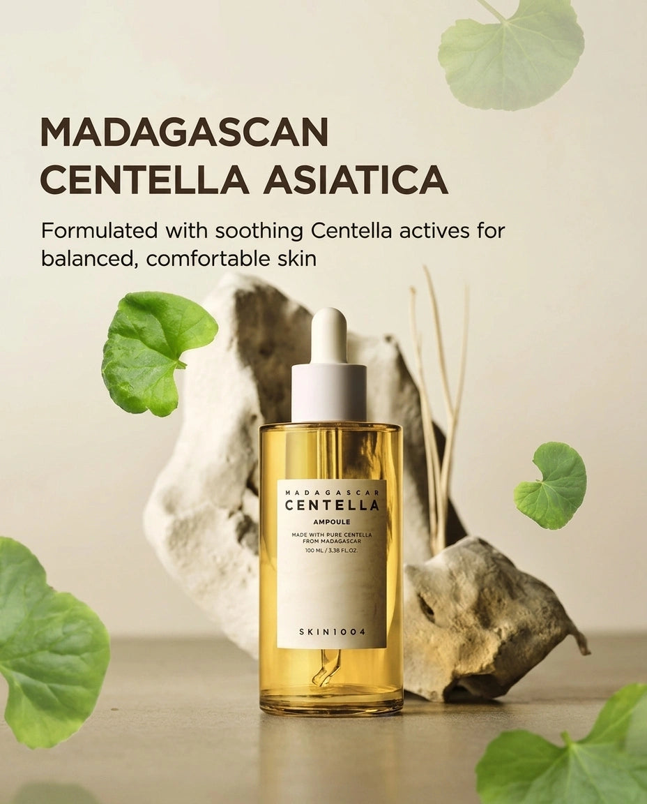 A bottle of SKIN1004 Madagascar Centella Asiatica Ampoule serum, featuring golden-yellow liquid in a clear bottle with a white dropper cap, styled with green leaves and natural stones on a neutral beige background.
