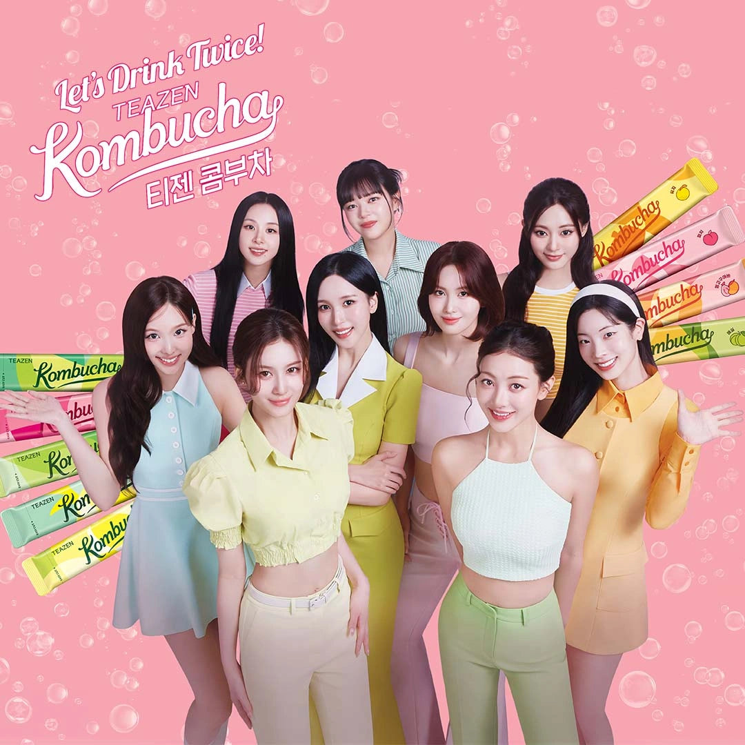 Group of women posing with Kombucha products on a pink background