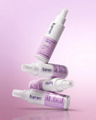 Four Baren personal care spray bottles in white and lavender purple, arranged in a stacked, floating composition on a soft pink-lavender gradient background.