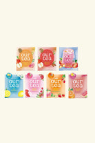 Six colorful 'our tea' product pouches arranged in two rows on a plain light beige background. The top row contains three peach, red, and blue pouches, and the bottom row contains three peach, pink, orange, and blue pouches, each decorated with fruit illustrations.