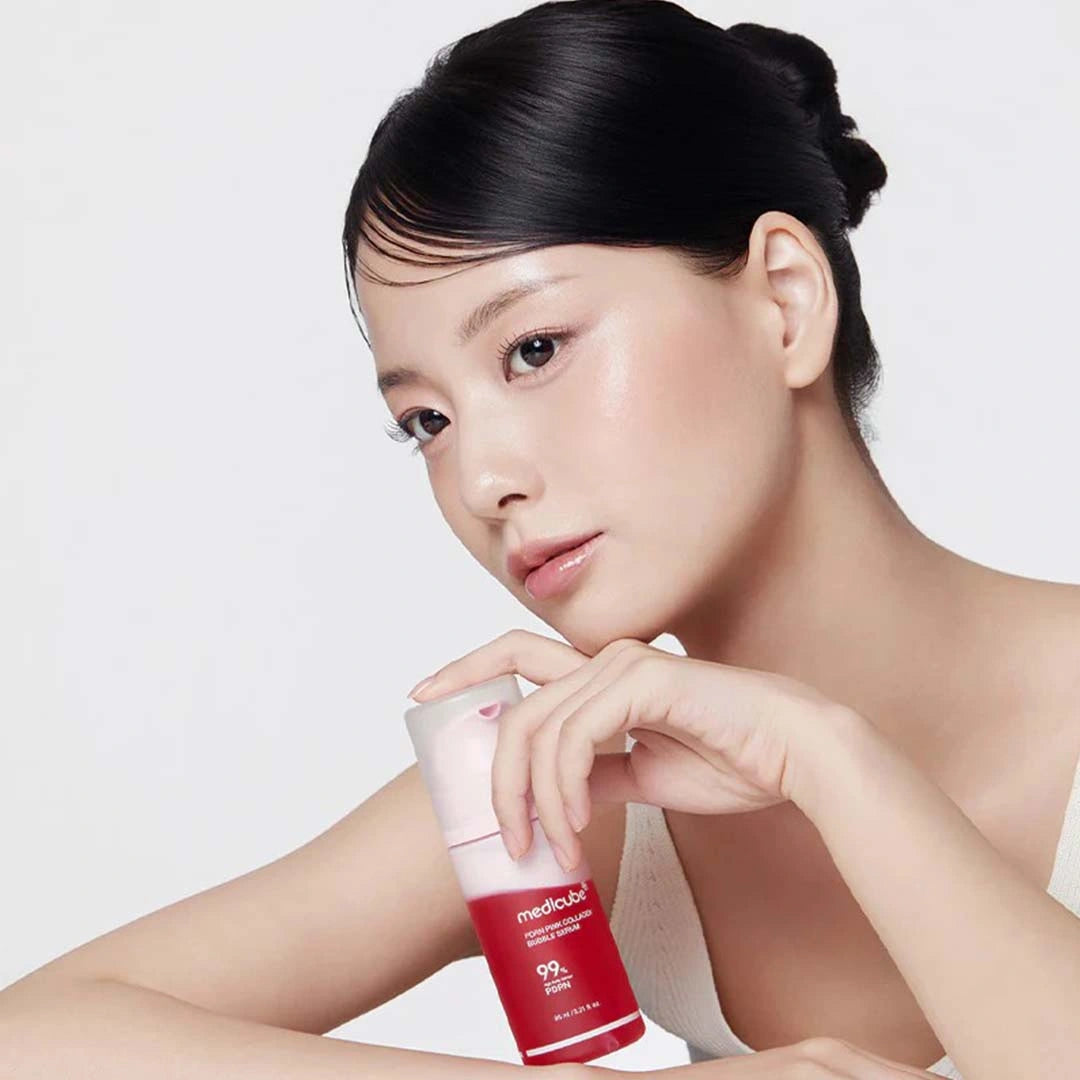 Woman holding a red skincare product with a white background