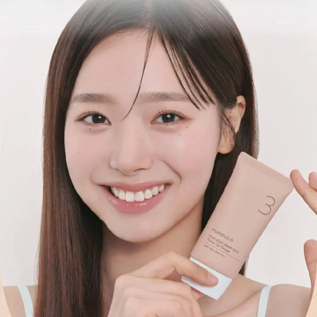 Woman holding a skincare product with a plain background
