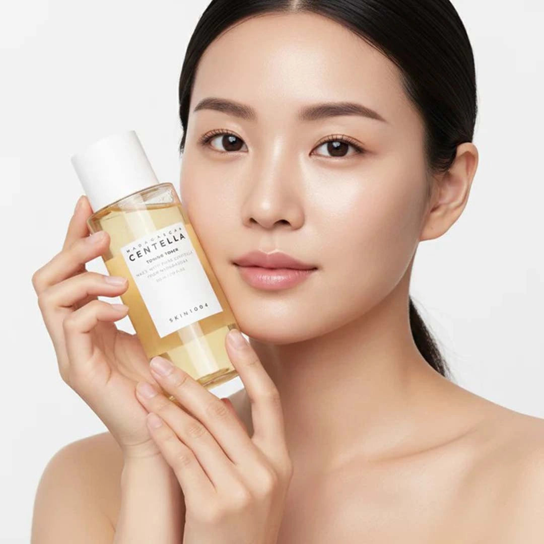 Woman holding a bottle of skincare product with a neutral background