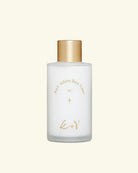 A frosted glass bottle of Koy Volume Base Toner with a metallic gold cap and gold lettering, centered on a solid cream background.